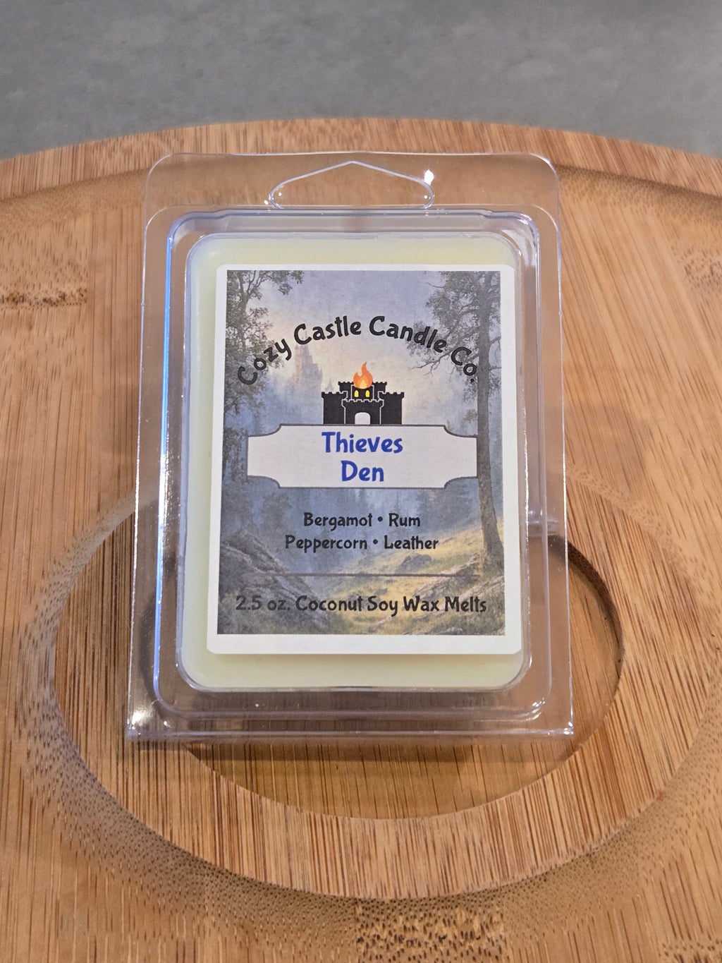 Wax Melts labeled "Thieves Den" on a textured wooden surface.