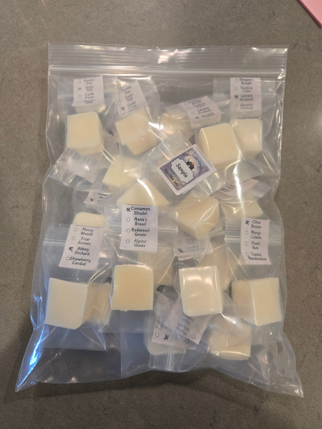 Individually Packaged wax melt cubes with labels on a gray surface